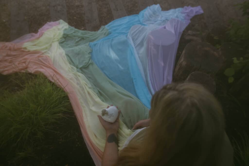 Samantha wears the rainbow skirt. She holds a white heart with her son's name.