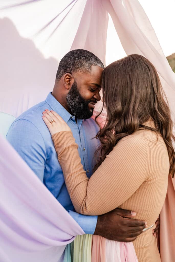 Alex and her husband stand close as the rainbow skirt surrounds them.